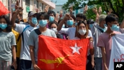 FILE - Protesters hold the flag of the National League for Democracy party of ousted Myanmar leader Aung San Suu Kyi at a rally against the military coup in Yangon, Myanmar, on May 9, 2021. The junta will execute five democracy activists on Sept. 24, 2024, a rights group says.