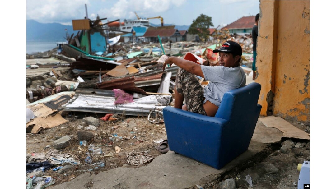 A man sits on a chair in the shell of a house heavily damaged by the tsunami in Wani village on the outskirts of Palu, Central Sulawesi, Indonesia, Oct. 4, 2018.