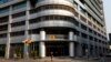 FILE - A woman walks past the head office of Angolan state oil company Sonangol in the capital Luanda, Aug. 26, 2012. 