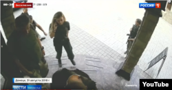 A woman in Zakharchenko's entourage using a cellphone moments before the bomb goes off despite claims of an advanced radio jamming system being activated. (Screengrab from "News of the Week with Dmitry Kisleyov, Rossiya 1).