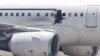 A gaping hole is visible in the side of a plane operated by Daallo Airlines as it sits on the runway of the airport in Mogadishu, Somalia, Feb. 2, 2016. 