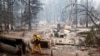 A firefighter extinguishes a hot spot in a neighborhood destroyed by the Camp Fire in Paradise, California, Nov. 13, 2018. 