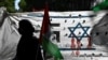 Seorang pengunjuk rasa memegang bendera Palestina saat unjuk rasa mendukung rakyat Palestina di depan kedutaan Israel di Buenos Aires, pada 9 Oktober 2023, setelah Israel memberlakukan pengepungan total di Jalur Gaza dan memutus pasokan air. (Foto: AFP)