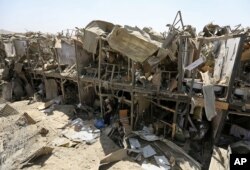 A security guard stands amid the damage of a truck bombing, in Kabul, Afghanistan, Monday, Aug. 1, 2016.