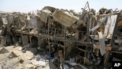 A security guard stands amid the damage of a truck bombing, in Kabul, Afghanistan, Monday, Aug. 1, 2016. 