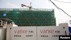 上海一栋建筑工地门口悬挂着万科标志。万科总裁传被公安带走的消息传出后，星期五股价暴跌逾8%。(路透社：2017年3月21日)