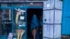 An Afghan woman wearing a burka exits a small shop in Kabul, Afghanistan, Sunday, Dec. 5, 2021.