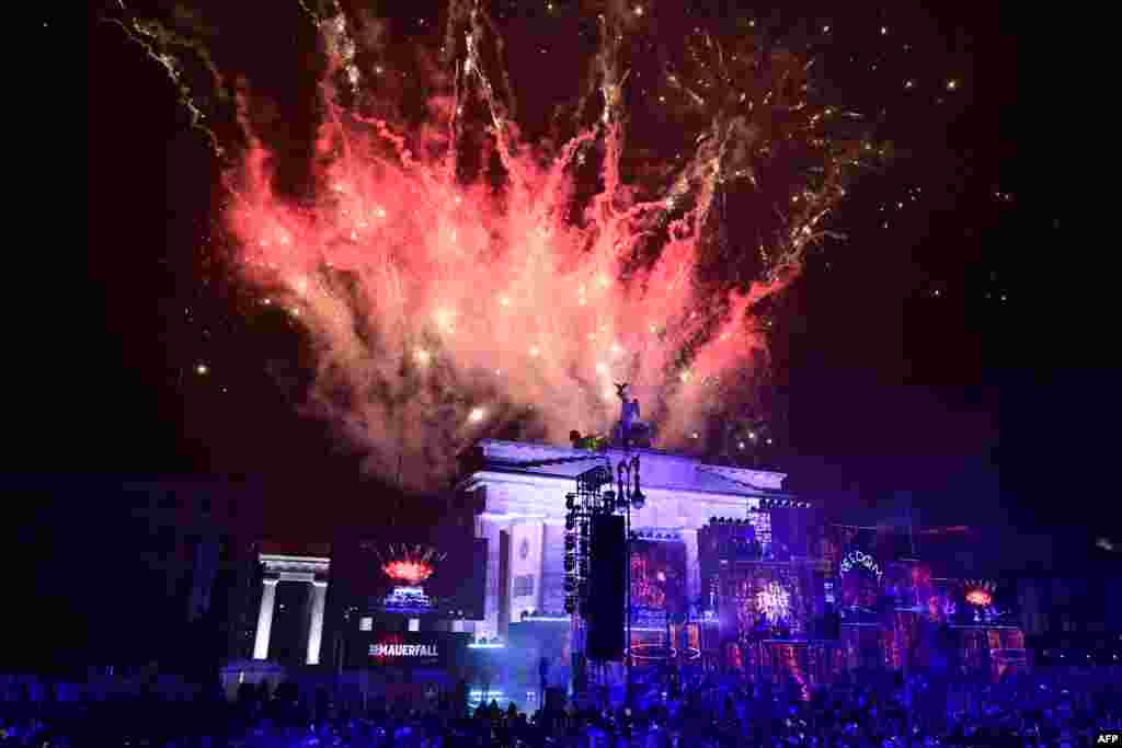 Fireworks ligthen the sky over the Brandenburg gate as musicians play on stage during the Konzert für Freiheit" (concert for freedom) for the 35th anniversary of the fall of the Berlin Wall, Nov. 9, 2024 in Berlin, Germany.