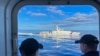 Sebuah kapal Garda Pantai China bermanuver di sebelah kapal Garda Pantai Filipina saat misi membawa pasokan baru di perairan Laut China Selatan yang dalam sengketa, 10 November 2023. (Foto: Jim Gomez/AP Photo)