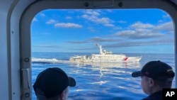 Sebuah kapal Garda Pantai China bermanuver di sebelah kapal Garda Pantai Filipina saat misi membawa pasokan baru di perairan Laut China Selatan yang dalam sengketa, 10 November 2023. (Foto: Jim Gomez/AP Photo)