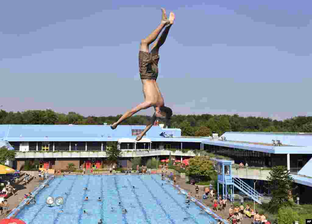 A boy jumps into a public pool on a hot day in Gelsenkirchen, Germany.
