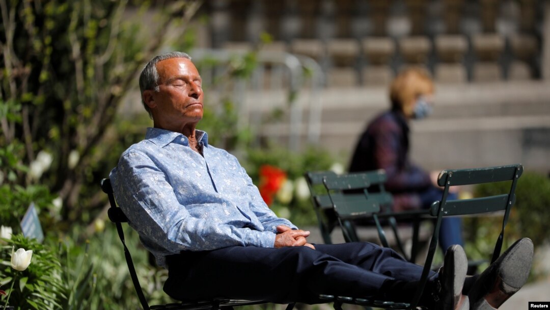 A person sits in Bryant Park after the Centers for Disease Control and Prevention announced new guidelines regarding outdoor mask-wearing and vaccination during the outbreak of the coronavirus, in Manhattan, New York City, New York, April 27, 2021.