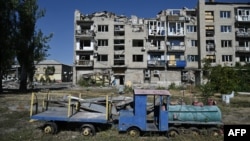 This photograph shows an abandoned playground next to a heavily damaged building in the city of Pokrovsk, Donetsk region, September 24, 2024, amid Russia's invasion of Ukraine.