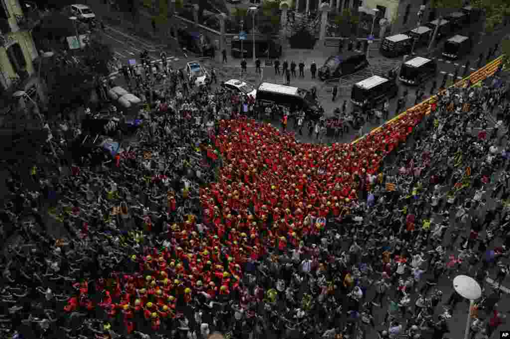 Firefighters join protesters outside the Spanish police headquaters during a one-day strike in Barcelona, Spain, Oct. 3, 2017. Labor unions and grassroots pro-independence groups are urging workers to hold partial or full-day strikes throughout Catalonia to protest alleged brutality by police during a referendum on the region's secession from Spain that left hundreds of people injured.