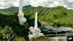 中國電視節目截屏，畫面字幕：東部戰區火箭軍部隊對台島東部外海預定海域實施常導火力突擊全部精準命中目標。-美聯社提供照片