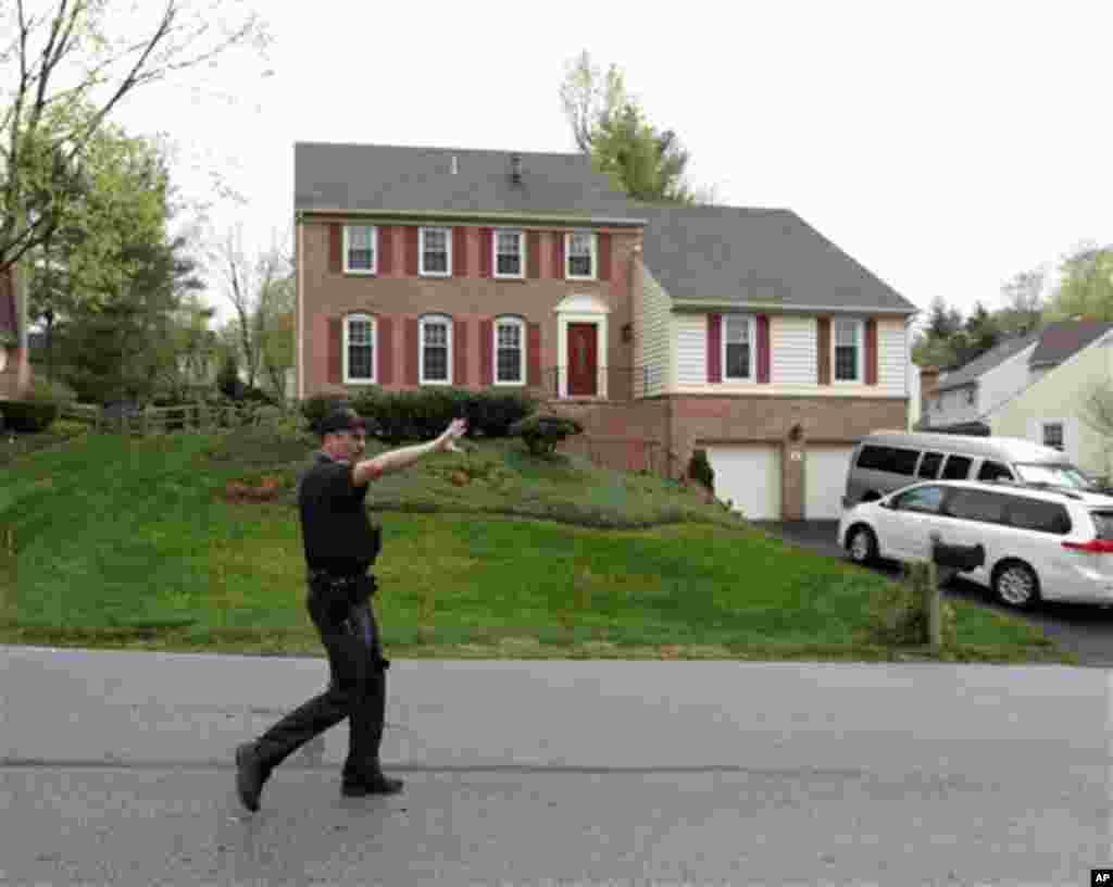 A Montgomery County, Maryland police officer pushes the media back from in front of the house of the uncle of the Boston Marathon bombing suspects, April 19, 2013, in Montgomery Village.