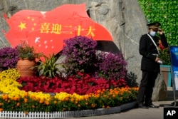 一名保安站在北京街頭一處慶祝中共二十大的花壇旁。 （2022年10月9日）