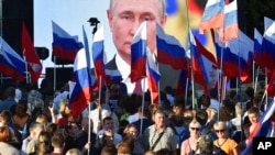 People gather in front of a large screen to celebrate the incorporation of regions of Ukraine into Russia, in Sevastopol, Crimea, Sept. 30, 2022. (AP Photo)