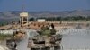 Anggota dari kelompok jihadis Hayat Tahrir al-Sham (HTS) membawa perlengkapan militer milik mereka di pinggiran Kota Afrin, Suriah, pada 13 Oktober 2022. (Foto: AFP/Rami al Sayed)