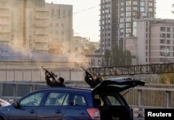 Police officers shoot at a drone during a Russian drone strike, which local authorities consider to be Iranian-made Shahed-136 unmanned aerial vehicles (UAVs), in Kyiv, Oct. 17, 2022.