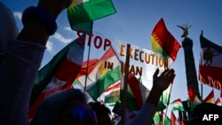 FILE - Protesters hold up a placard reading "Stop Execution in Iran" at a rally in Berlin, Oct. 22, 2022. Britain has joined the effort targeting the death penalty in Iran, with more then 250 members of the U.K. Parliament condemning the practice.