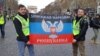  French far-right activists Xavier Moreau (left) and Fabrice Sorlin holding the flag of "DNR" during protests of "yellow vests" in Paris.