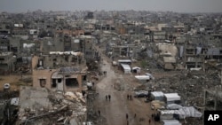 Warga Palestina berjalan di tengah reruntuhan rumah dan bangunan yang hancur di lingkungan Zeitoun, Kota Gaza, 7 Maret 2025.