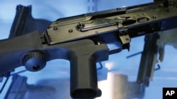 FILE - A little-known device called a "bump stock" is attached to a semiautomatic rifle at the Gun Vault store and shooting range, in South Jordan, Utah, Oct. 4, 2017. The device was used by Las Vegas shooter Stephen Paddock.