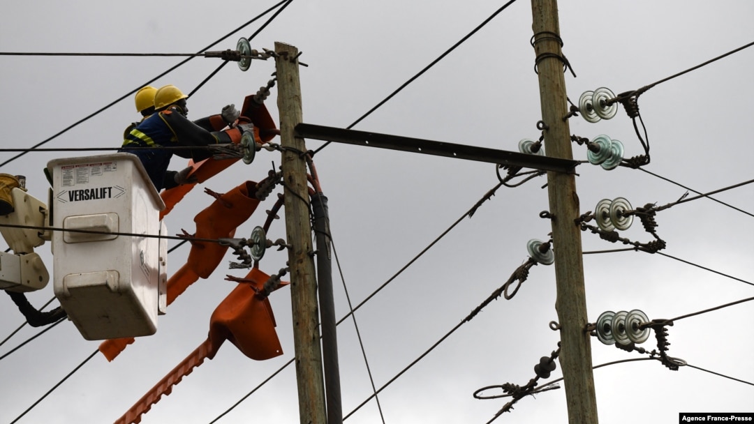 FILE - Kenya Power and Lighting Company (KPLC) live line experts relocate power lies to pave way for the construction of the Nairobi Expressway in Westlands, Nairobi, Sept. 24, 2020. 