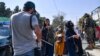 FILE - A Taliban member cracks down on journalists covering a women's rights protest in Kabul, Oct. 21, 2021.
