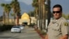 FILE - A police officer stands guard at the Dar Al Uloom Al Islamiyah-Amer mosque — where Syed Rizwan Farook was often seen — in San Bernardino, California, Dec. 4, 2015, two days after Farook and his wife shot 14 people to death at a Christmas party. 