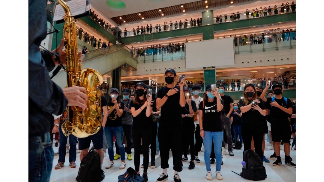 Protesters wearing masks in defiance of a recently imposed ban on face coverings perform at a shopping mall in Hong Kong, Oct.13, 2019.