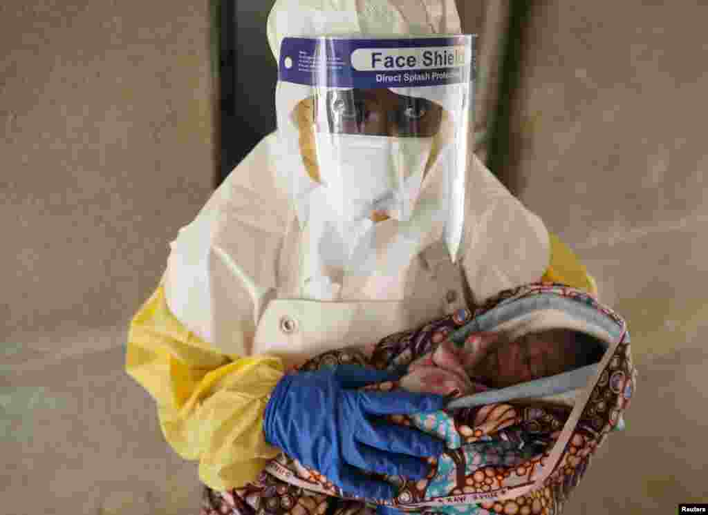 A health care worker carries a baby thought to be infected with the Ebola virus, in a hospital in Oicha, North Kivu Province of Democratic Republic of Congo.