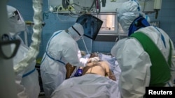 Medicinski radnici pomažu zaraženom od koronavirusa, u Zemunskoj bolnici u Beogradu, 26. novembra 2020. (Foto: Reuters/Marko Đurica)