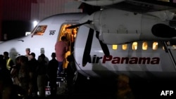 A handcuffed migrant boards a plane for a deportation flight to Ecuador, in the framework of the memorandum of cooperation signed between Panama and the U.S., at the Albrook "Marcos A. Gelabert" International Airport in Panama City, Sept. 20, 2024.