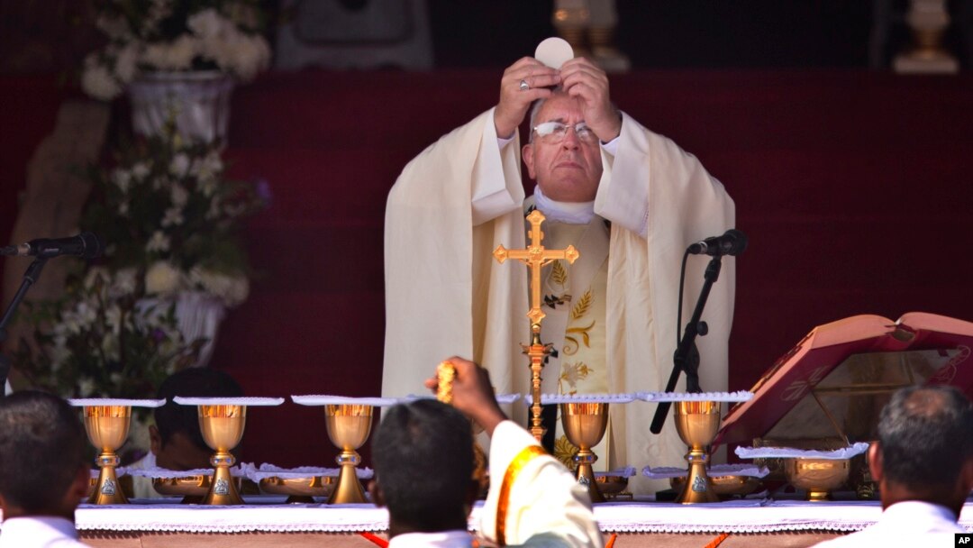 FILE - Pope Francis prepares for Holy Communion during mass at Colombo's seafront Galle Face Green, in Sri Lanka, Jan. 14, 2015.