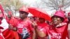 Botswana Democratic Party supporters wearing shirts displaying the portrait of President Mokgweetsi Masisi dance outside the High Court of Botswana in Gaborone, Sept, 28, 2024. 