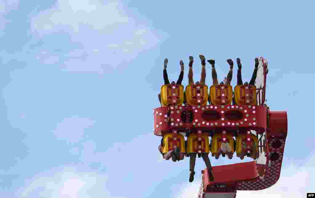 People sit in a fairground ride at the 184th Oktoberfest, Munich's annual beer festival in southern Germany.