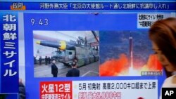 Žena prolazi pored TV ekrana preko koga se emituje vest o severnokorejskoj raketnoj probi, u Tokoju, Japan.
