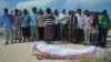 FILE - Relatives and fellow journalists pray as they stand next to the body of Somali journalist Abdulaziz Ali Haji during his funeral, Sept. 28, 2016, in Mogadishu. 