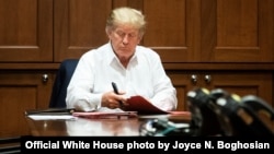 UMongameli Donald J. Trump usebenza ngesikhathi egula esibhedlela seWalter Reed National Military Medical Center eBethesda kwele Melika., Oct. 3, (Official White House photo by Joyce N. Boghosian)