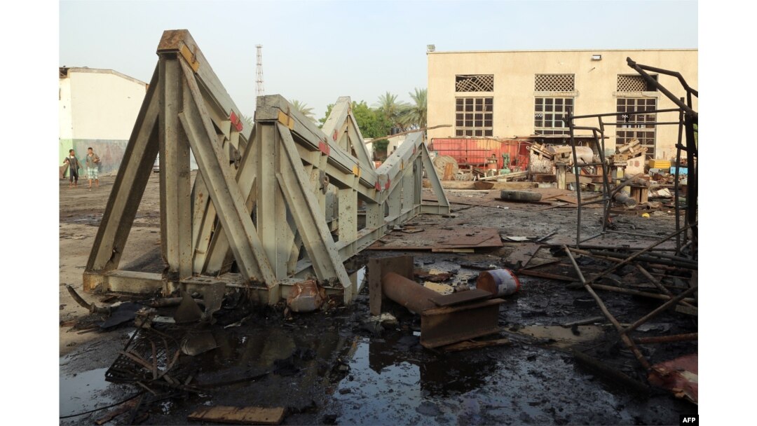Workers inspect damages at the site of an air strike on the maintenance hub at the Hodeidah port, on May 27, 2018.