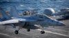 ເຮືອ​ບິນ​ລົບ FA-18 Super Hornet ບິນ​ລົງ​ຈອດ​ກຳ​ປັ່ນ​ບັນ​ທຸກ​ເຮືອ​ບິນ​ USS Ronald Reagan, 28 ຕຸ​ລາ 2015.(Kim Hong-Ji/Pool Photo via AP)