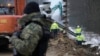 FILE - Workers build the first part of a wall intended to block migrants pushed by Belarus, in what the European Union calls a "hybrid attack," from crossing illegally into EU territory, in Tolcze, near Kuznica, Poland, on the border with Belarus, Jan. 27, 2022.