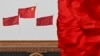 中国国旗在北京人大会堂悬挂的国徽上空飘扬。（资料照片）