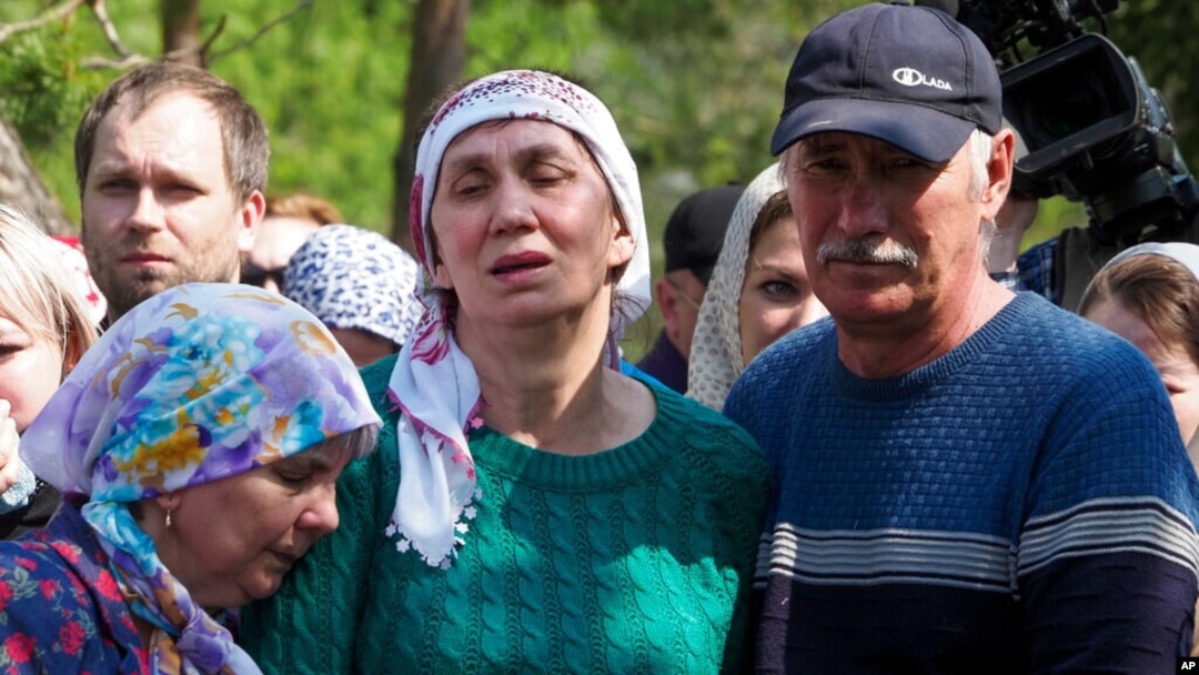 Relatives mourn during the funeral of Elvira Ignatieva, a teacher who was killed in a shooting at a school on Tuesday, in Kazan, Russia, May 12, 2021. 