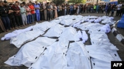 Palestinci iznad prekrivenih tela ubijenih u izraelskim bombardovanjima u Deir Balahu u centralnom delu Pojasa Gaze, u bolnici Šuhada al-Aksa, 6. novembra 2023.