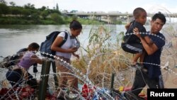 Migranti iz Venecuele probijaju se kroz bodljivkavu žicu nakon što su preko reke Rio Grande ušli u Sjedinjene Države, u Igl Pasu, 26. septembra 2023.