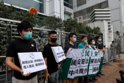 香港民主黨成員在中聯辦門口手舉標語抗議“港版國安法”。（2020年5月22日）