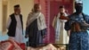 A Taliban fighter, right, and residents stand next to the bodies of civilians who were killed in an operation begun the night before by Taliban members against Islamic State Khorasan, the local chapter of the jihadist group, in Kandahar, Afghanistan, Nov. 15, 2021.
